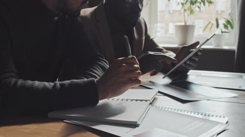 Businessmen Working Together On Statistics in Office