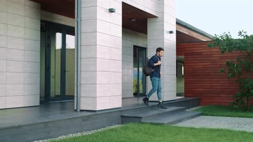 Man Walks From Suburban Home With Backpack