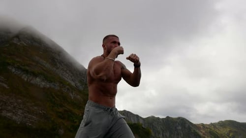 Powerful Man Boxing in a Mountainous Landscape
