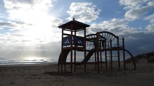 Ein leerer Kinderspielplatz am Strand. Zeitraffer. Herbstperiode und leicht bewölkt.