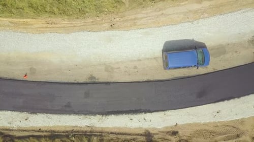 Aerial View of New Road Construction with Workers and Asphalt Laying Machinery at Work