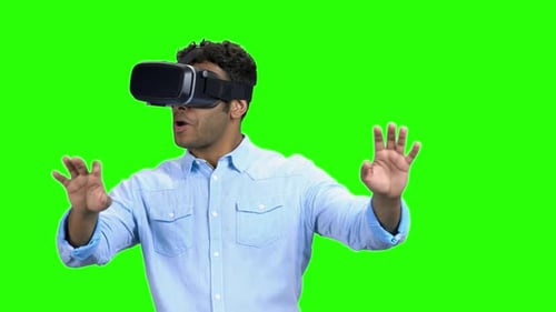 Young Adult Using Virtual Reality Headset on Green Screen