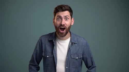 Man Expressing Surprise and Joy on Teal Background