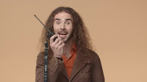 Man Communicating with Walkie-Talkie on Plain Background