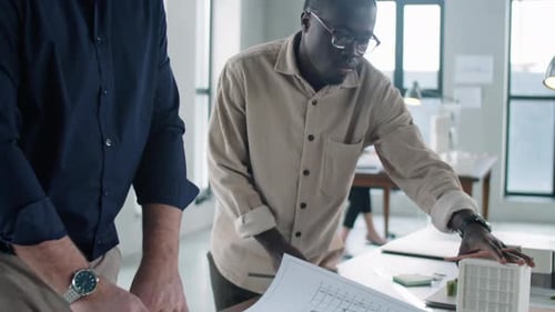Architects Reviewing Blueprints in Modern Office