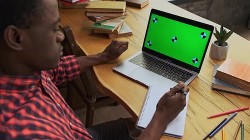 Adult Studying at Desk with Laptop Green Screen