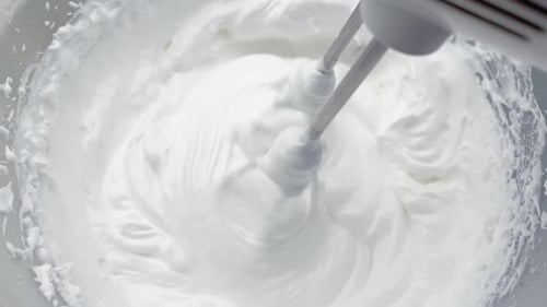 Electric Mixer Whipping Cream in Bowl