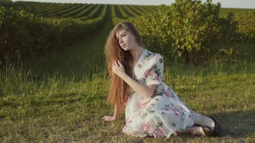 Woman in Floral Dress Sitting in Field