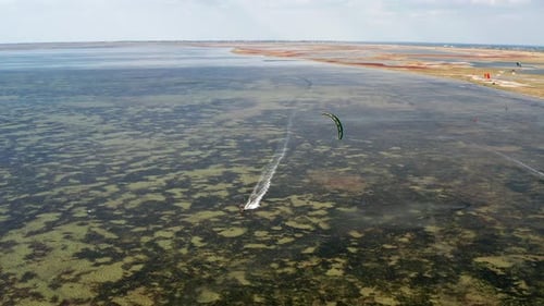 People go kitesurfing on the sea. The wind carries the athlete along the sea waves.