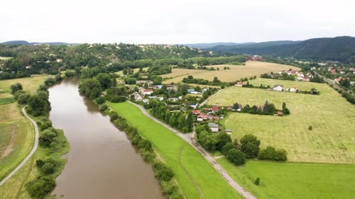 Aerial Drone Shot a Picturesque Village and a River in a Rural Area with Fields