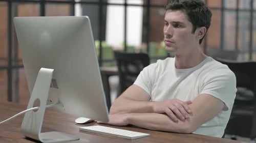 Mann denkt während der Arbeit am Computer