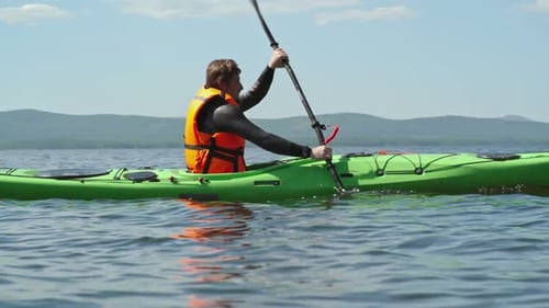 Man Kayaking on a Lake on a Sunny Day