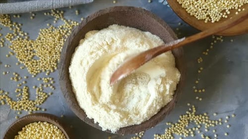 Hulled millet flour and grain in bowls top view