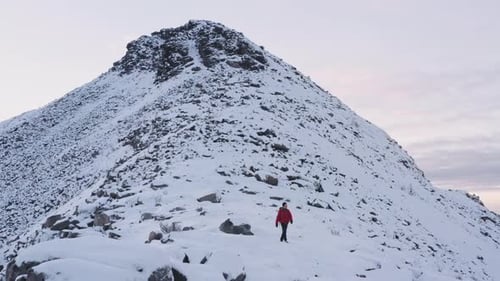 Adult Hiking Up a Snowy Mountain in Winter