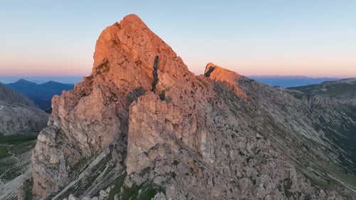 Dolomites mountains peaks with a hiking path on a summer sunrise