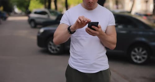 Cropped Shot Man Using Mobile Phone in a Summer City