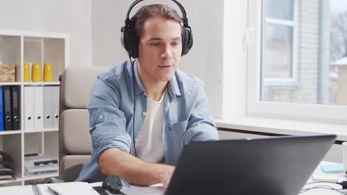 Workplace of freelance worker at home office. Young man works using computer.