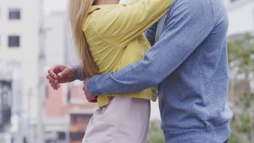 Side view of Caucasian couple cuddling in the street