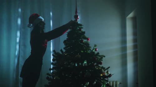 Woman Decorating Christmas Tree in Festive Setting