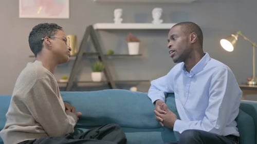 Couple Having Serious Conversation While Sitting on Sofa
