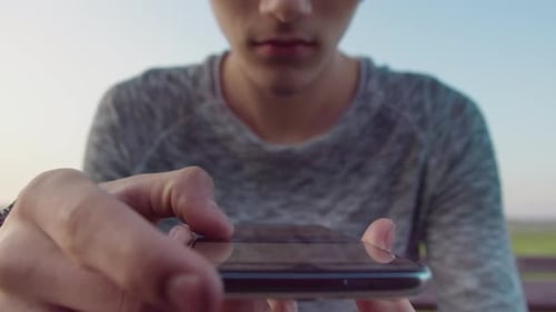 Young Adult Using Phone in Urban Setting