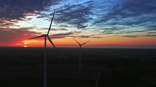Aerial view of sunset with wind turbines on farm field
