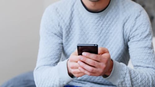 Man using mobile phone in bedroom