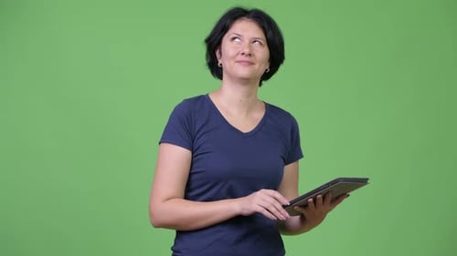 Woman Using Tablet Against Green Background