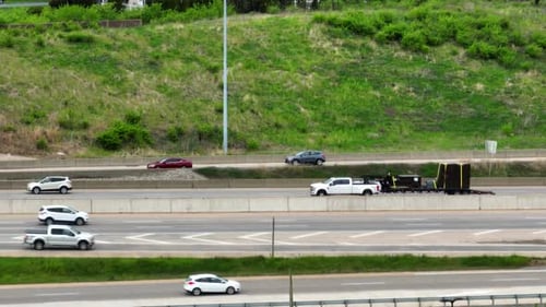Traffic and busy highway scene. Cars and trucks vehicles on expressway. Tight aerial zoom in view.