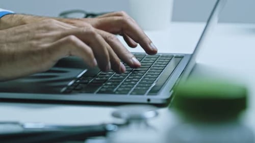 The Doctor Works at the Computer in His Office