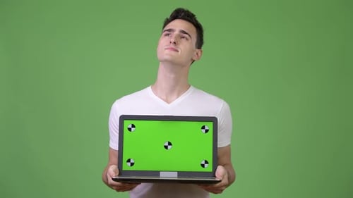 Young Adult Holding Laptop With Green Screen