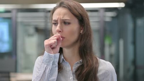 Young Adult Woman Coughing in Office Setting