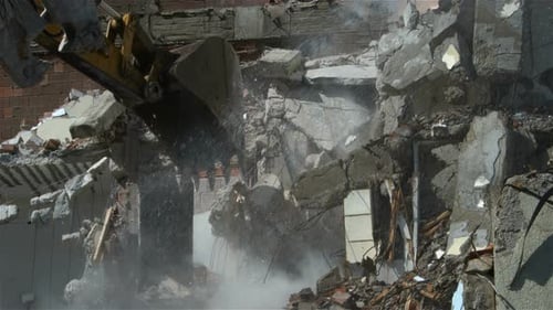 Excavator Demolishing Damaged Brick and Concrete Building