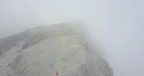 Aerial drone view of a woman hiking in the mountains