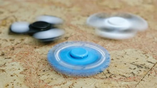 Trois Spinner tournant sur une table en bois