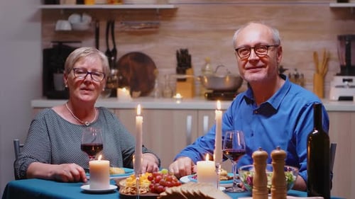 Senior Couple Talking at Candlelit Dinner at Home