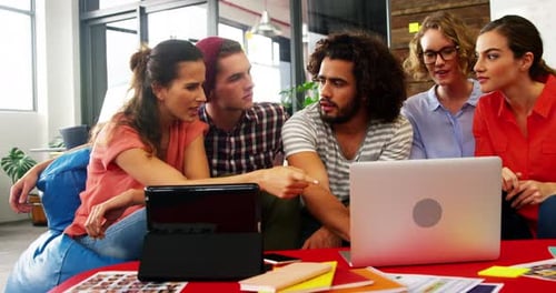 Team Collaborating on Laptop in Modern Office