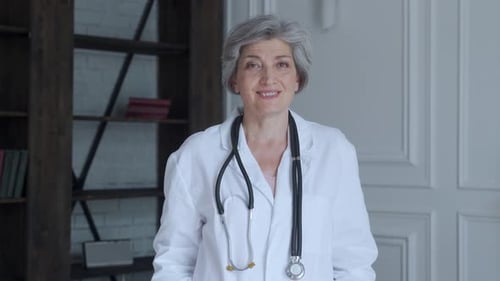 Smiling Senior Woman Doctor in White Coat