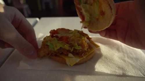 Male Hands Take a Burger in a Fast Food Cafe a Guy Bites a Burger and Lays It on the Table