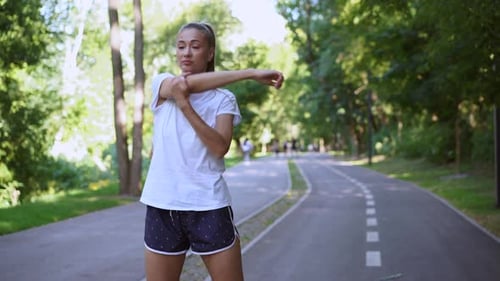 Woman Runner Stretching Arms Before Exercising Summer Park Morning