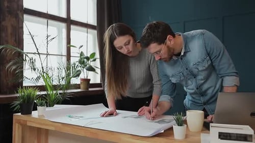 Young Woman and Man As an Architects Working with Blueprints, Laptop and House Models in the Office.