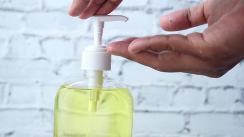 Close Up of Young Man Hand Using Sanitizer Gel for Preventing Virus