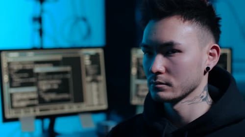 Asiatischer Hacker im dunklen Raum mit Computern bei Nacht 45