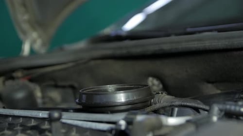 Adding Oil to Car Engine in Garage