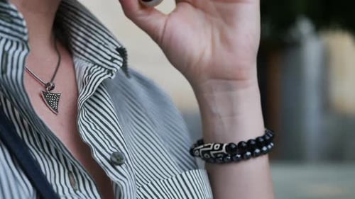 Adult Wearing Jewelry and Talking on Phone