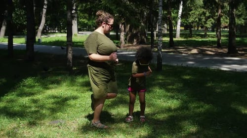 White Woman and Her Black Daughter Doing Simple Sport Exercises in the Park