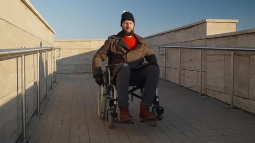 Handicapped Man Moving Down Wheelchair Ramp in the City