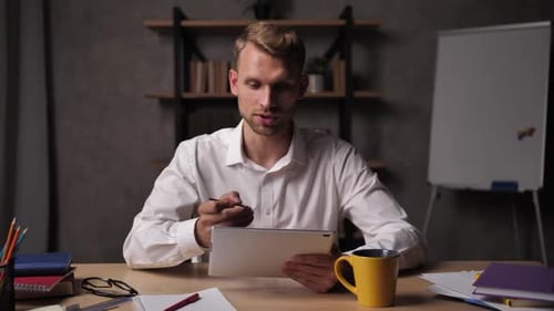 Young Adult Uses Tablet in Office Setting