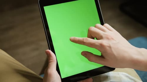 A Mockup of a Man Holds a Tablet Computer with Chroma Key Screen in His Hands