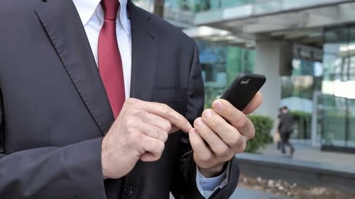Close Up of Walking Businessman Browsing on Smartphone